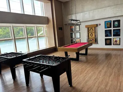 two ping pong tables in a room with windows at 10L Luxe City Escape at Park Mckinley West in Manila