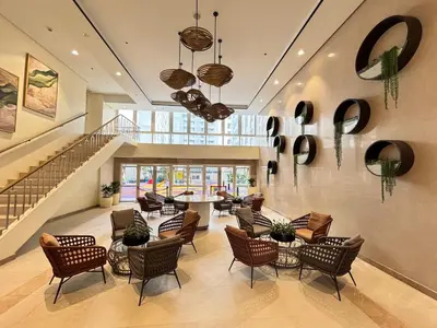 a lobby with chairs and tables and a staircase at 10L Luxe City Escape at Park Mckinley West in Manila