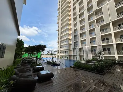 a large building with a wooden deck in front of a building at 10L Luxe City Escape at Park Mckinley West in Manila