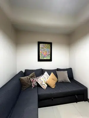 a blue couch with pillows on it in a room at 10L Luxe City Escape at Park Mckinley West in Manila