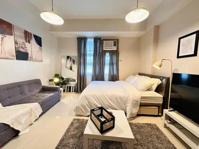 a large bedroom with a bed and a couch at 101 Newport Boulevard near NAIA Terminal 3 in Manila