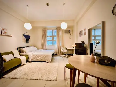 a bedroom with a bed and a table in a room at 101 Newport Boulevard near NAIA Terminal 3 in Manila