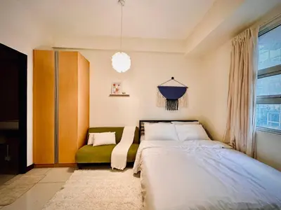 a bedroom with a bed and a green couch at 101 Newport Boulevard near NAIA Terminal 3 in Manila