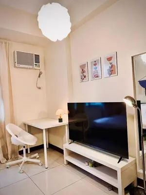 a living room with a large television and a desk at 101 Newport Boulevard near NAIA Terminal 3 in Manila