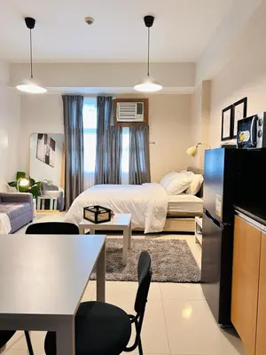 a bedroom with a bed and a living room at 101 Newport Boulevard near NAIA Terminal 3 in Manila