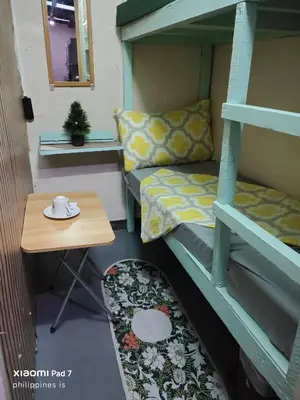 a small room with a bunk bed and a table at Bunkaroo in Manila