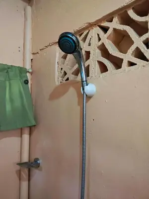a shower in a room with a wall at Bunkaroo in Manila