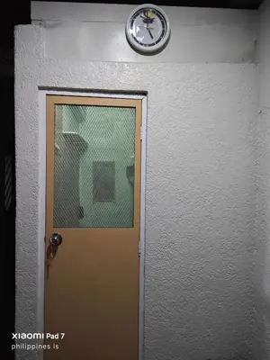 a clock above a door with a clock above it at Bunkaroo in Manila