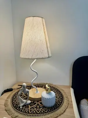 a lamp sitting on a table with a figurine on it at J&A Cozy Calm Stay in Biñan