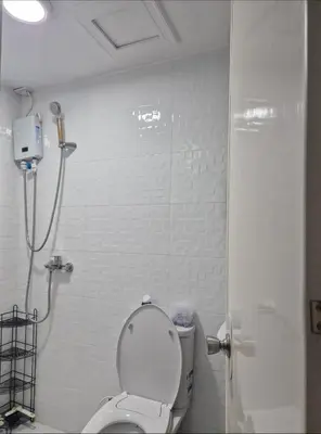 a bathroom with a toilet and a shower in it at 1BR Retro-styled Condo unit in BGC, Taguig City in Manila