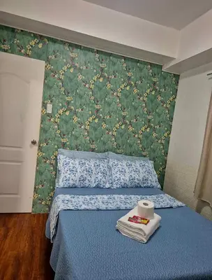 a bedroom with a blue bed with a green wall at 1BR Retro-styled Condo unit in BGC, Taguig City in Manila