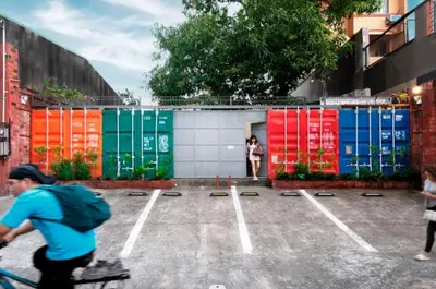 a man riding a bike in a parking lot withcolored containers at Container Home Mandaluyong N01 in Manila