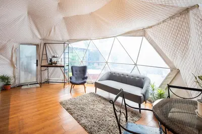 a living room with a couch and a chair in a tent at Container Home Mandaluyong N01 in Manila