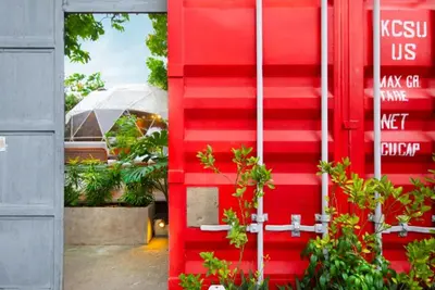 a red door with plants in front of a building at Container Home Mandaluyong N01 in Manila