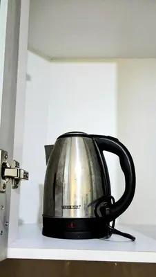 a tea kettle sitting on a shelf in a kitchen at Cozy Modern Studio Two Palm Tree Villas in Manila