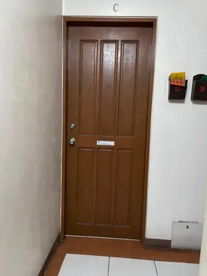 a brown door in a room with a white wall at Studio Type Manila in Manila
