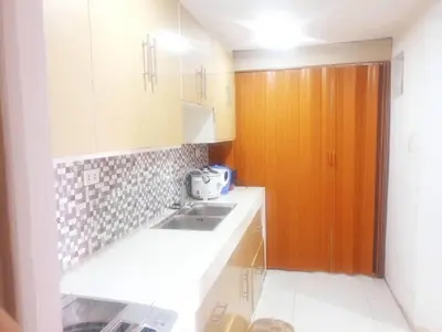 a kitchen with a sink and a wooden door at Fernica Boarding House in Bancal