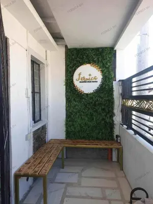 a bench against a green wall with a sign on it at Fernica Boarding House in Bancal