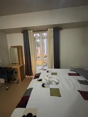 a bedroom with a bed and a desk and a window at Family Suite-150Newport Boulevard Southwing in Manila