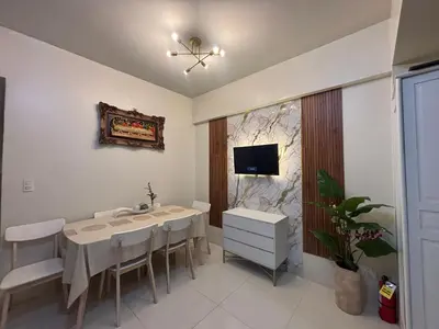 a dining room with a table and a tv on the wall at Family Suite-150Newport Boulevard Southwing in Manila