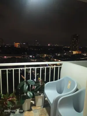a balcony with a chair and potted plants at night at JC Palace Residence in Manila