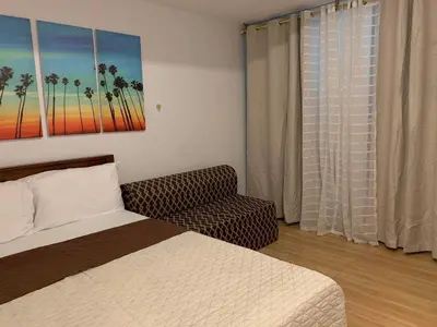 a bedroom with a bed and a couch and a window at Azure Urban Resort Residence A51 in Manila