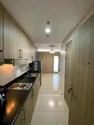 a large kitchen with wooden cabinets and black counter tops at Vacation at HM Place in Manila