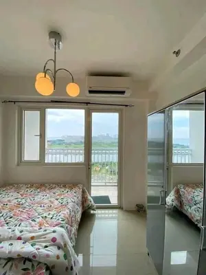 a bedroom with a bed and a large window at Vacation at HM Place in Manila