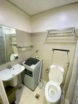 a bathroom with a white toilet and a sink at Vacation at HM Place in Manila