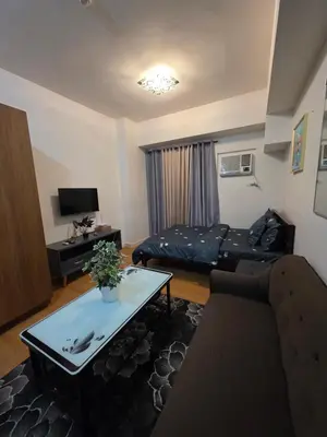 a living room with a bed and a couch at 8 Adriatico Condominium in Manila
