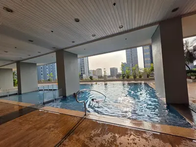 a large swimming pool in a building with a city skyline at 8 Adriatico Condominium in Manila