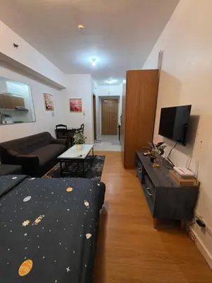 a living room with a couch and a tv at 8 Adriatico Condominium in Manila