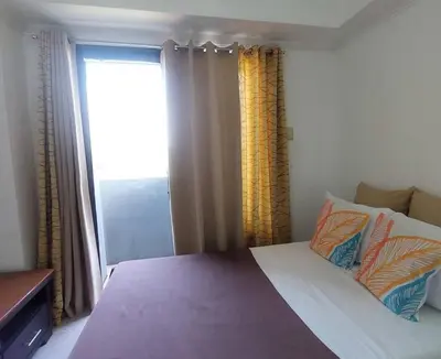 a bedroom with a large bed with a window at Condotels by Mandolin Suite in Manila