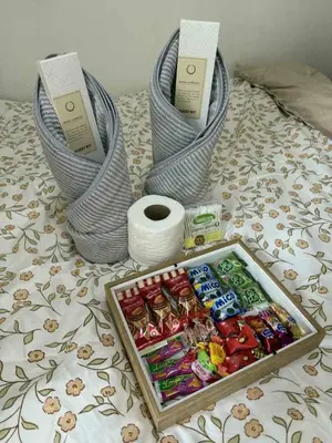a tray of candy and toilet rolls on a bed at shore residences admin in Manila