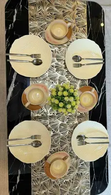 a table with plates and utensils and a plant at shore residences admin in Manila