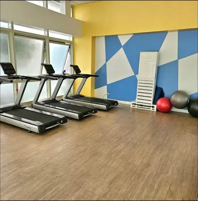 a gym with several treadmills in a room at J&A Cozy Calm Stay in Biñan