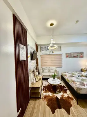 a bedroom with a bed and a living room with a table at J&A Cozy Calm Stay in Biñan