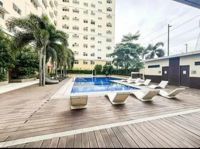 a courtyard with a pool and chairs and a building at J&A Cozy Calm Stay in Biñan