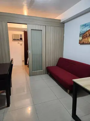 a living room with a red couch and a table at Apartment in Pasay at Shore Residences in Manila