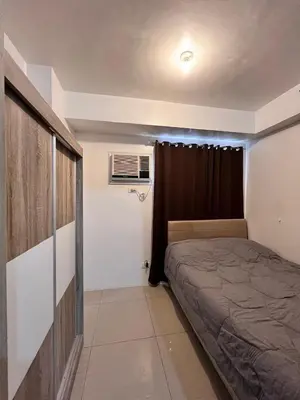 a small bedroom with a bed and a window at Apartment in Pasay at Shore Residences in Manila