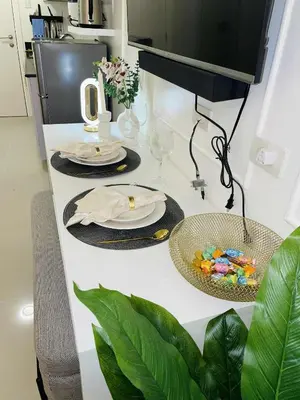 a table with two plates and glasses and a plant at ASV Condo Staycation SMDC Breeze in Manila