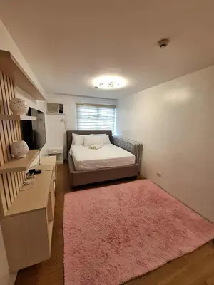 a bedroom with a bed and a pink rug at LSB Modern Penthouse in Manila