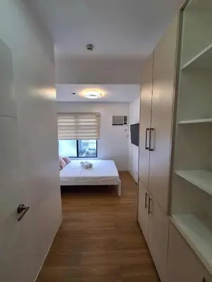 a small bedroom with a bed and a window at LSB Modern Penthouse in Manila