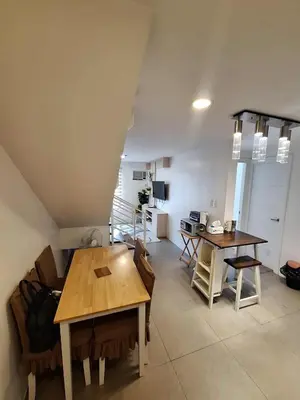 a dining room with a table and chairs in a room at LSB Modern Penthouse in Manila