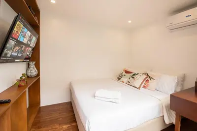 a bedroom with a white bed and a tv at Container Home Mandaluyong N05 in Manila