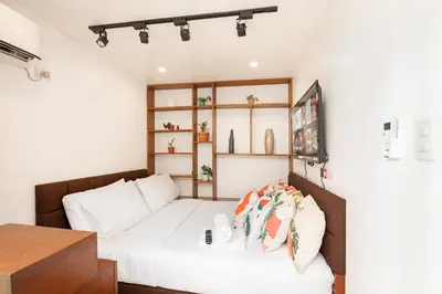 a bedroom with a bed with white sheets at Container Home Mandaluyong N07 in Manila