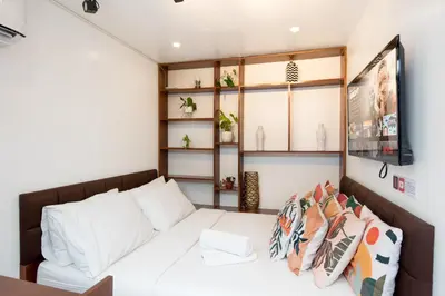 a living room with a white bed and shelves at Container Home Mandaluyong N08 in Manila