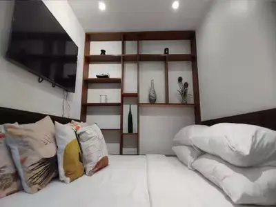 a bedroom with a bed with pillows and a tv at Container Home Mandaluyong N10 in Manila