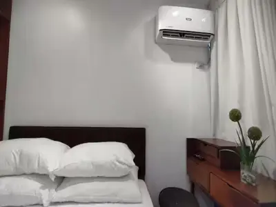 a bedroom with a bed and a dresser with a heater at Container Home Mandaluyong N10 in Manila