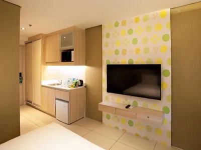 a kitchen with a large flat screen tv on a wall at Hotel101 - Manila in Manila